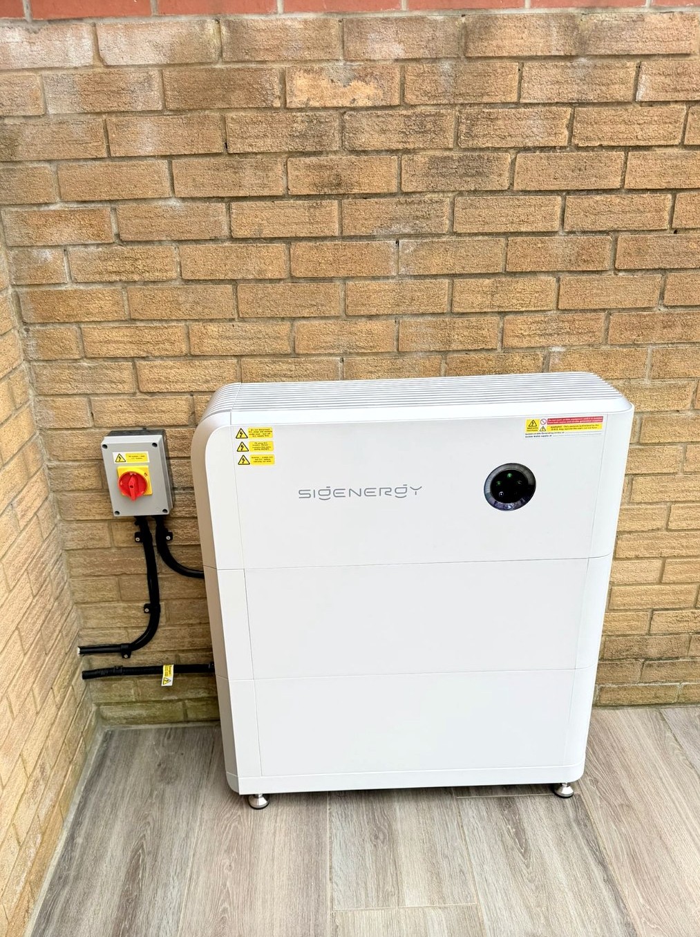 Outdoor SigEnergy stack with EV charger on brick